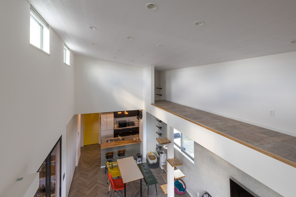 Exempel på ett modernt loftrum, med vita väggar, vinylgolv och grått golv
