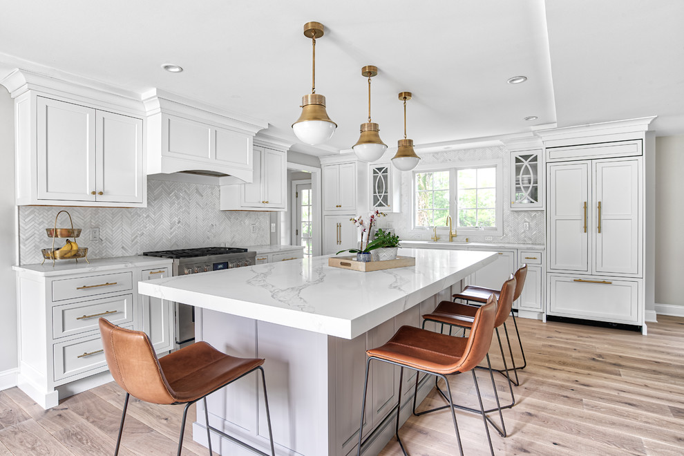 Photo of a large transitional l-shaped eat-in kitchen in New York with panelled appliances, light hardwood floors, with island, beige floor, an undermount sink, white cabinets, quartz benchtops, white splashback, mosaic tile splashback, white benchtop and shaker cabinets.