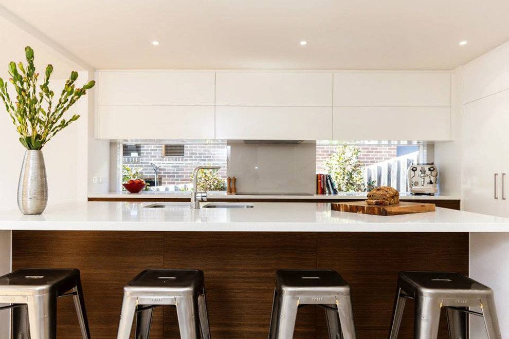 This is an example of a contemporary u-shaped eat-in kitchen in Melbourne with an undermount sink, recessed-panel cabinets, white cabinets, quartz benchtops, grey splashback, glass sheet splashback and with island.