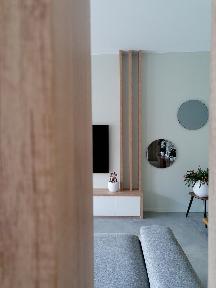 Exemple d'une salle de séjour scandinave de taille moyenne et ouverte avec un mur vert, un sol en carrelage de céramique, un téléviseur fixé au mur, un sol gris et du papier peint.