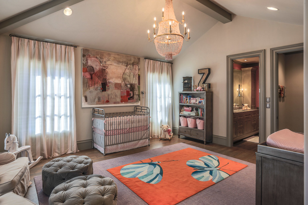 Design ideas for a large transitional nursery for girls in Dallas with beige walls and dark hardwood floors.