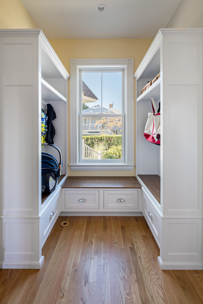 Inspiration for a small transitional mudroom in Boston with yellow walls and medium hardwood floors.