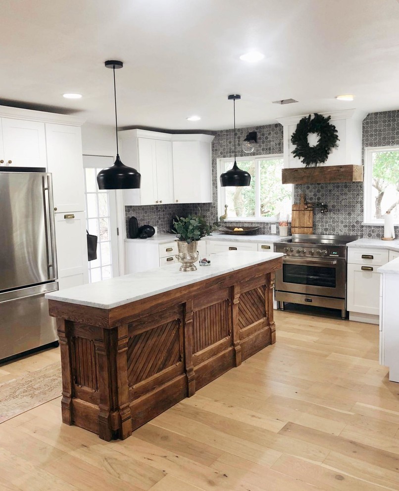 Inspiration for a mid-sized transitional u-shaped light wood floor eat-in kitchen remodel in Austin with an undermount sink, shaker cabinets, white cabinets, marble countertops, gray backsplash, marble backsplash, stainless steel appliances, an island and white countertops