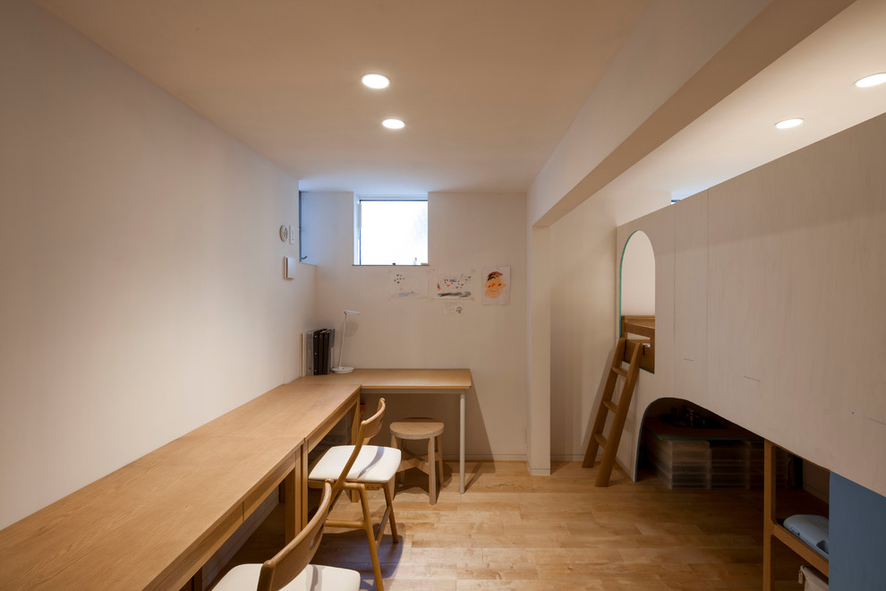 This is an example of an asian kids' bedroom in Yokohama with white walls, light hardwood floors and brown floor.