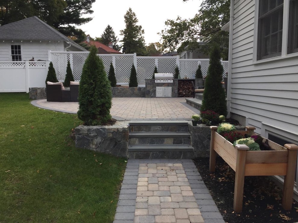 Example of a mid-sized transitional backyard concrete paver patio design in Orange County with a fire pit and no cover