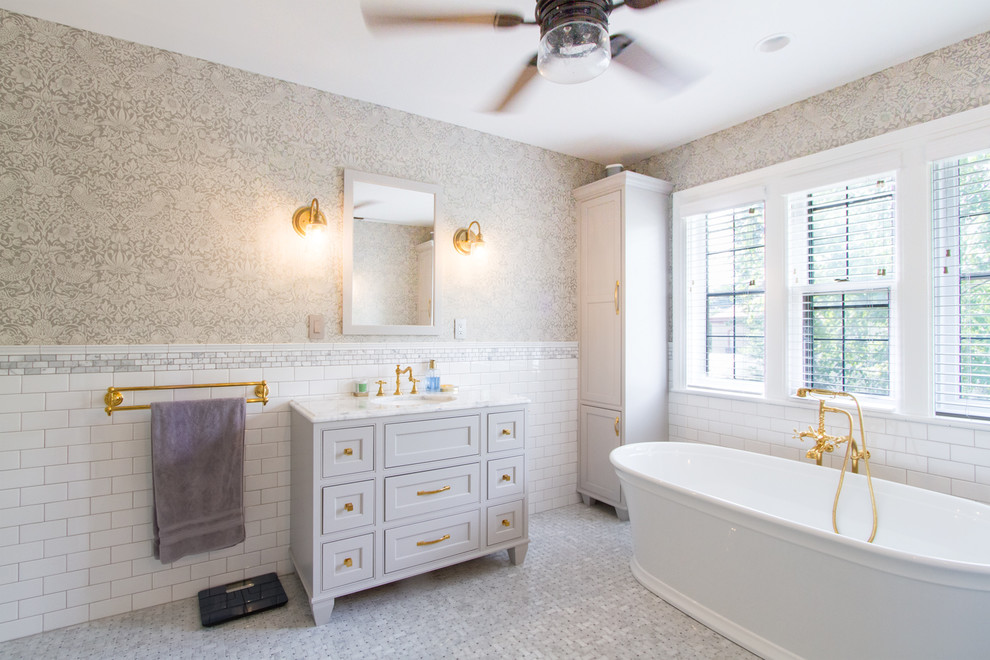 Photo of a large traditional master bathroom in Milwaukee with beaded inset cabinets, grey cabinets, a freestanding tub, an alcove shower, a one-piece toilet, white tile, subway tile, grey walls, marble floors, an undermount sink, quartzite benchtops, grey floor, a hinged shower door and yellow benchtops.