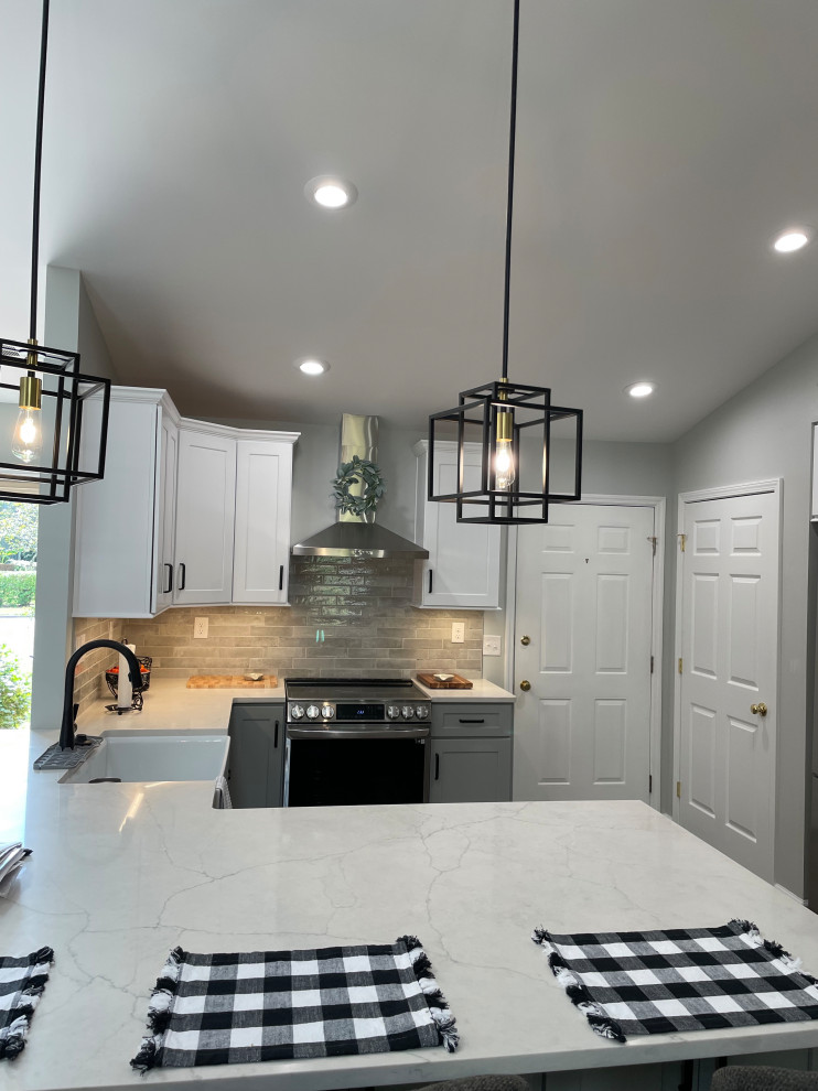 Kitchen - mid-sized transitional u-shaped kitchen idea with a farmhouse sink, shaker cabinets, white cabinets, quartz countertops, gray backsplash, subway tile backsplash, stainless steel appliances, no island and white countertops