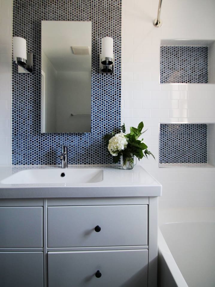This is an example of a small modern bathroom in Denver with flat-panel cabinets, white cabinets, an alcove tub, a shower/bathtub combo, a one-piece toilet, white tile, porcelain tile, blue walls, porcelain floors, an integrated sink and engineered quartz benchtops.
