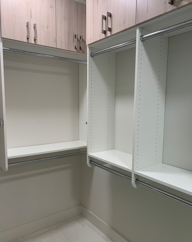 Photo of a mid-sized modern gender-neutral walk-in wardrobe in Atlanta with light wood cabinets.