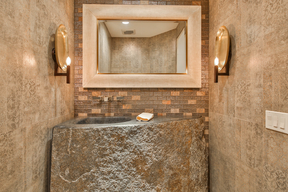 Photo of a mid-sized country powder room in Other with beige tile, ceramic tile, beige walls, cement tiles, an integrated sink, limestone benchtops and grey floor.