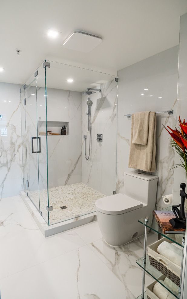 Пример оригинального дизайна: большая ванная комната в стиле модернизм с плоскими фасадами, белыми фасадами, угловым душем, разноцветной плиткой, плиткой из листового камня, разноцветными стенами, полом из керамогранита, душевой кабиной, врезной раковиной, столешницей из искусственного кварца, разноцветным полом, душем с распашными дверями, серой столешницей, нишей, тумбой под две раковины, подвесной тумбой и унитазом-моноблоком