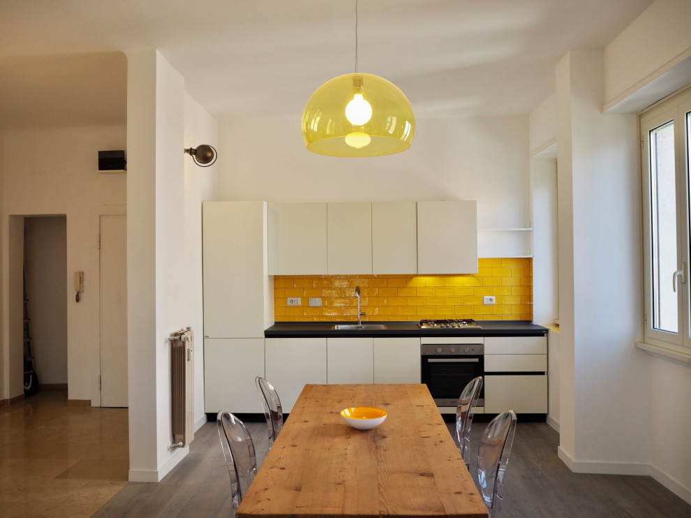 Ispirazione per una cucina contemporanea di medie dimensioni con top in superficie solida, paraspruzzi giallo, paraspruzzi con piastrelle in ceramica, parquet chiaro e top grigio