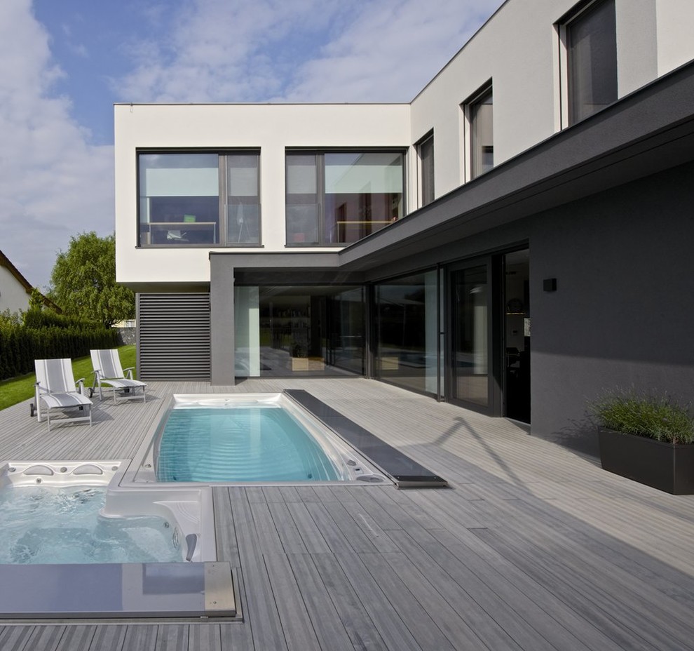 Large modern backyard rectangular pool in Other.