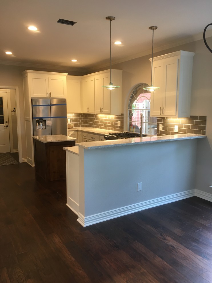 Inspiration for a mid-sized transitional u-shaped eat-in kitchen in Dallas with shaker cabinets, white cabinets, granite benchtops, grey splashback, stainless steel appliances, with island, subway tile splashback, dark hardwood floors and blue floor.