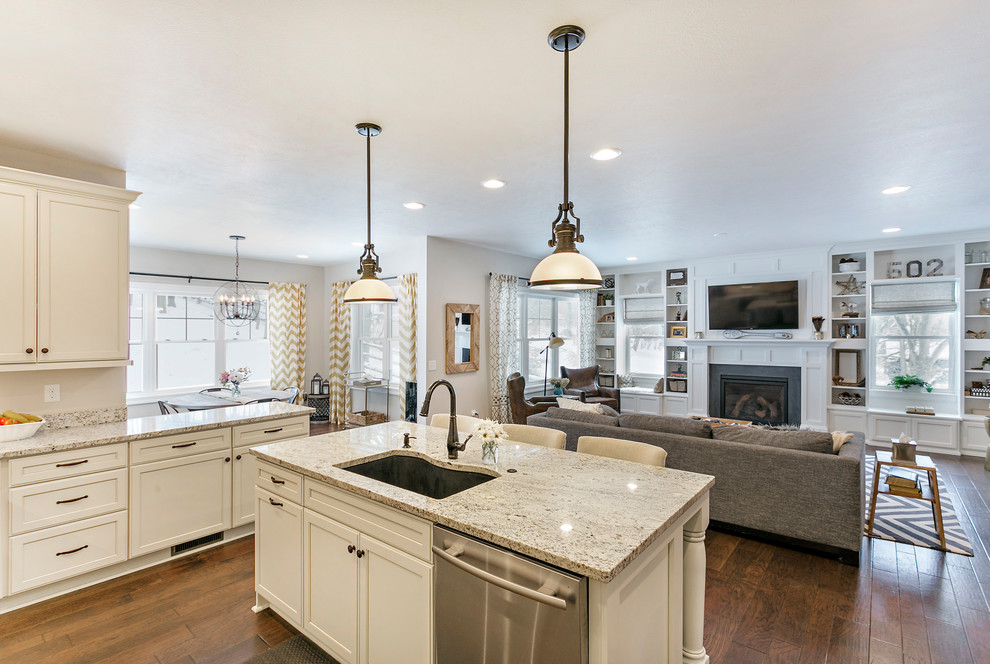 Inspiration for a large arts and crafts l-shaped eat-in kitchen with an undermount sink, shaker cabinets, white cabinets, granite benchtops, beige splashback, stainless steel appliances, medium hardwood floors and with island.