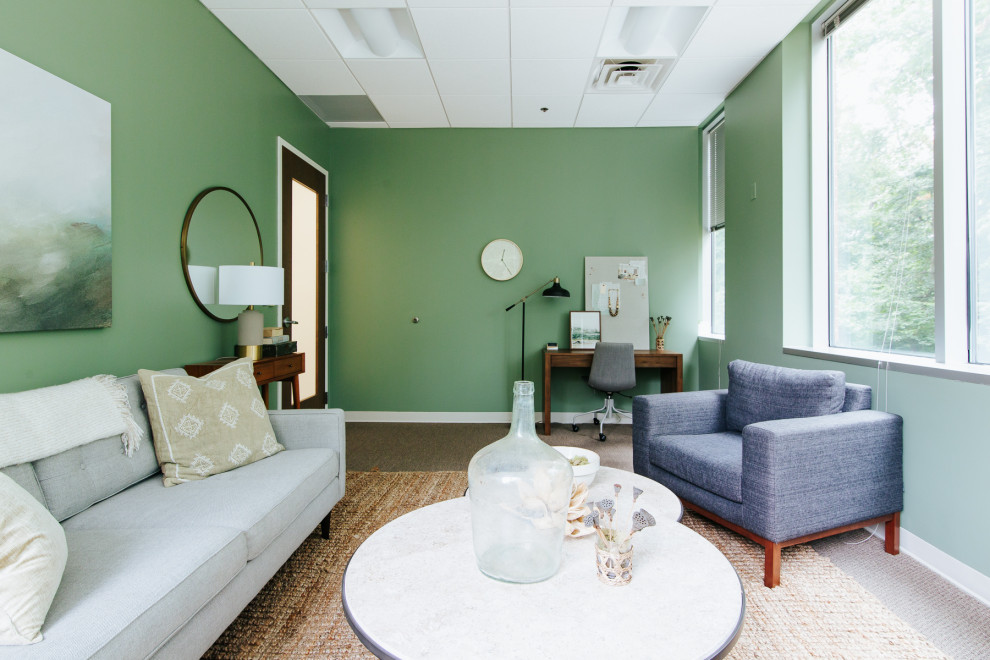This is an example of an expansive modern home office in Baltimore with green walls and brown floors.