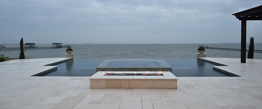 Inspiration for a large transitional backyard stone and custom-shaped infinity hot tub remodel in Houston