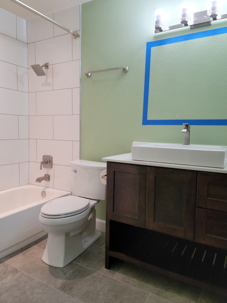 Aménagement d'une salle de bain rétro en bois foncé de taille moyenne avec un placard à porte shaker, une baignoire en alcôve, un combiné douche/baignoire, WC séparés, un carrelage blanc, des carreaux de porcelaine, un mur vert, un sol en carrelage de céramique, une vasque, un plan de toilette en quartz modifié, un sol gris, une cabine de douche avec un rideau, un plan de toilette blanc, une niche, meuble simple vasque et meuble-lavabo sur pied.