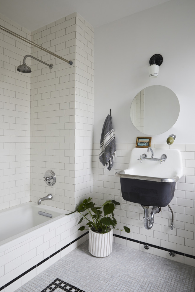 Small classic family bathroom in New York with white tiles, ceramic tiles, white walls, a wall-mounted sink, grey floors, a single sink, black cabinets, a built-in bath, mosaic tile flooring, a shower/bath combination, a two-piece toilet and a shower curtain.