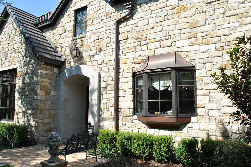Design ideas for a large traditional two-storey beige exterior in Austin with a gable roof and stone veneer.