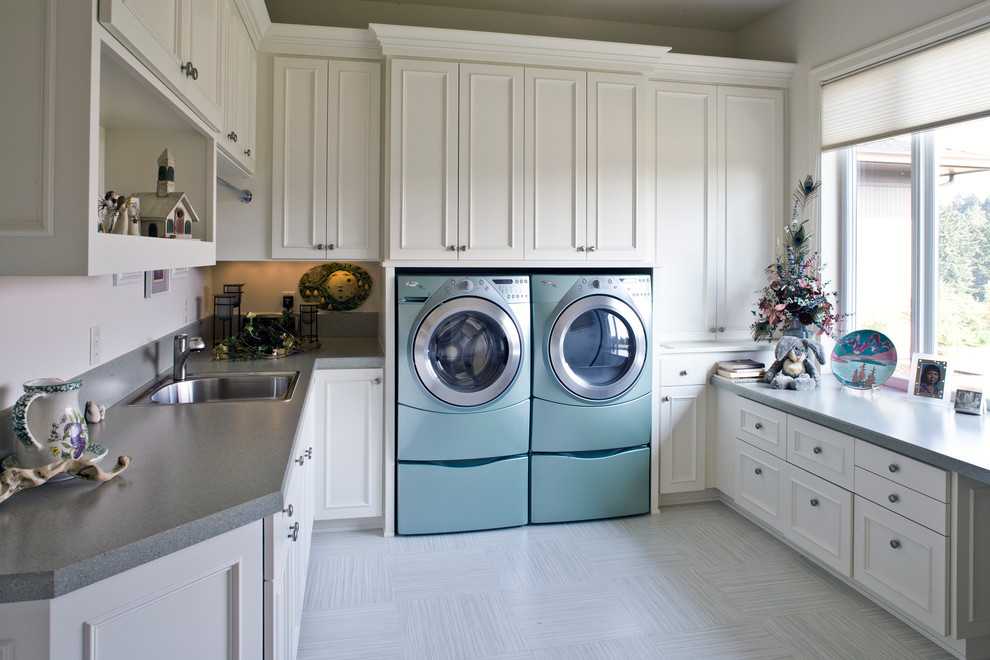 Photo of a traditional laundry room in Portland with a drop-in sink, white cabinets, a side-by-side washer and dryer and grey benchtop.