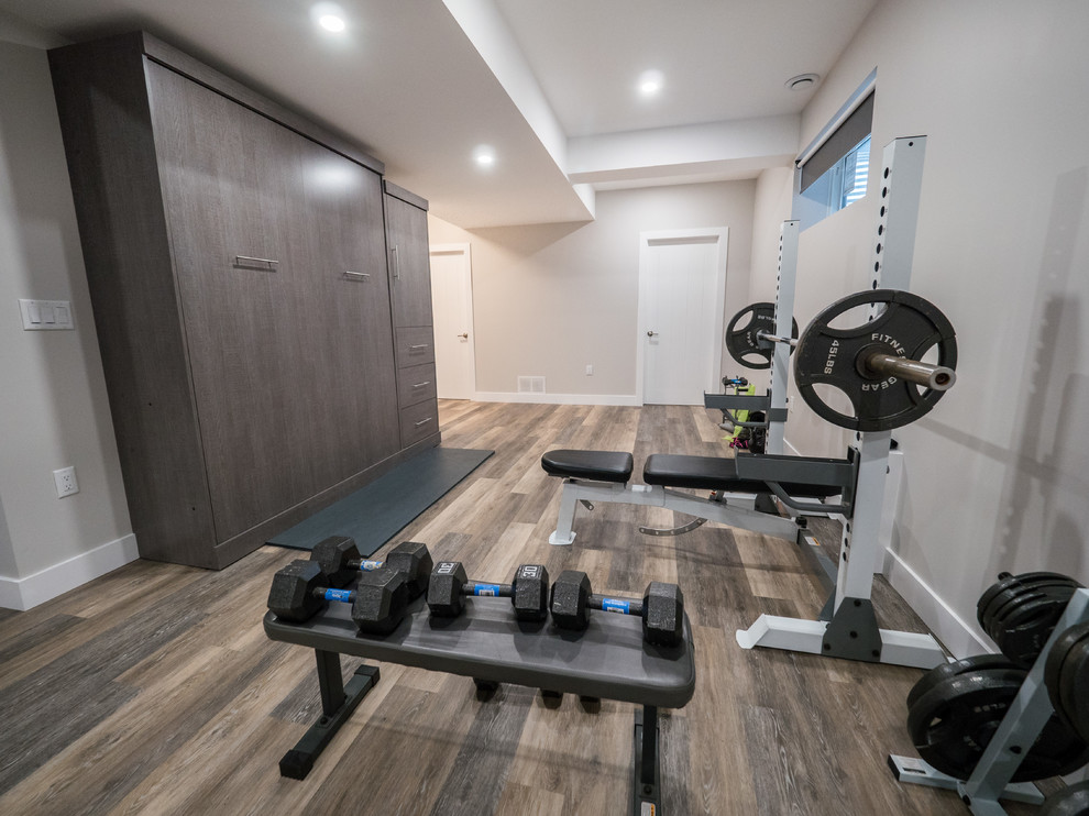 Mid-sized trendy look-out medium tone wood floor and gray floor basement photo in Edmonton with gray walls