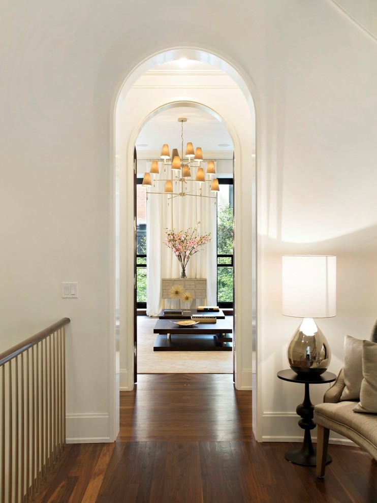 Transitional hallway in New York with white walls and dark hardwood floors.