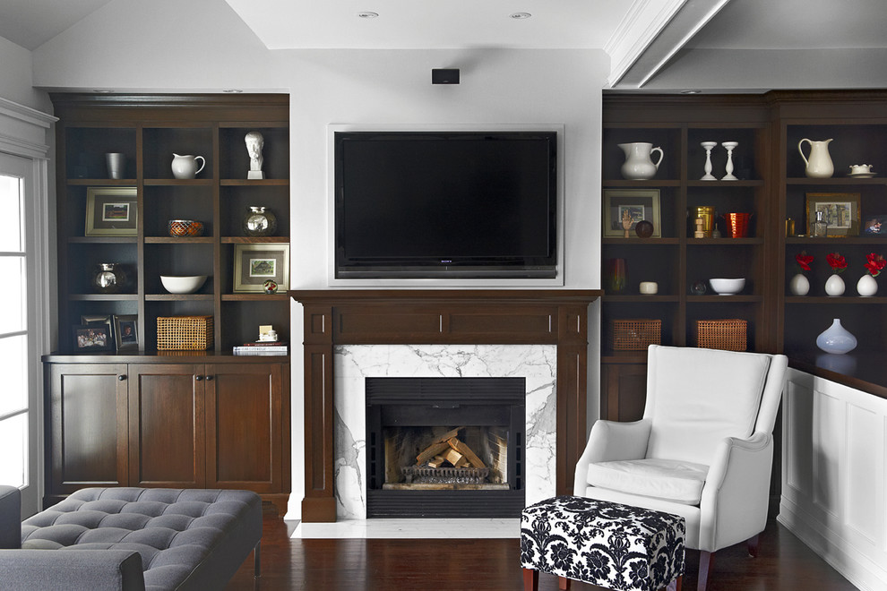 This is an example of a mid-sized traditional enclosed family room in Toronto with white walls, dark hardwood floors, a standard fireplace, a tile fireplace surround and a wall-mounted tv.