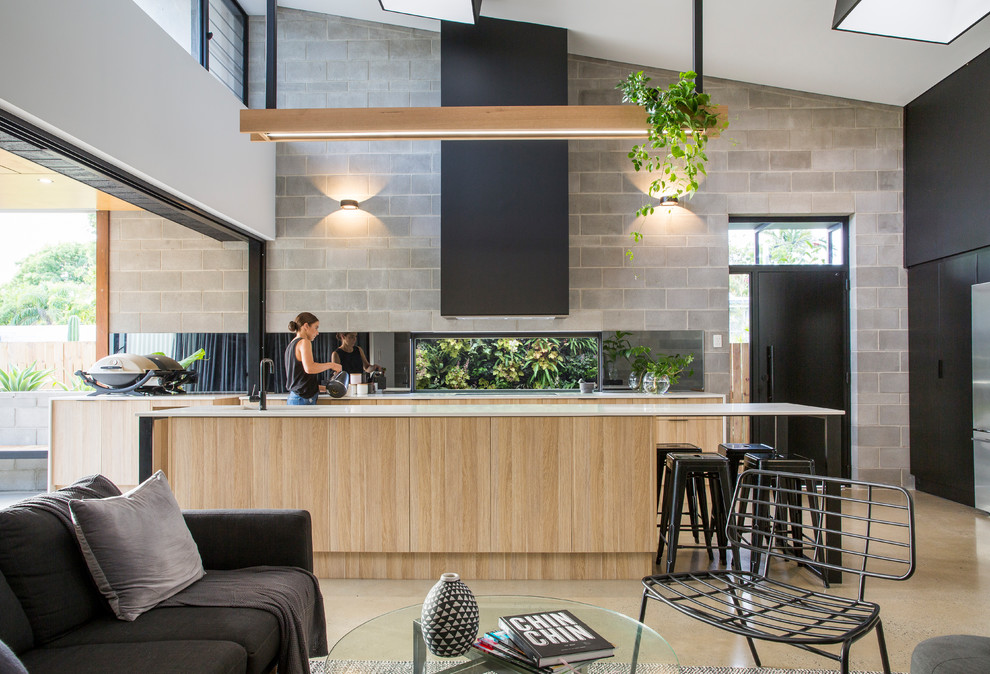 Inspiration for a contemporary open plan kitchen in Sydney with flat-panel cabinets, black cabinets, grey splashback, stainless steel appliances, concrete floors and with island.