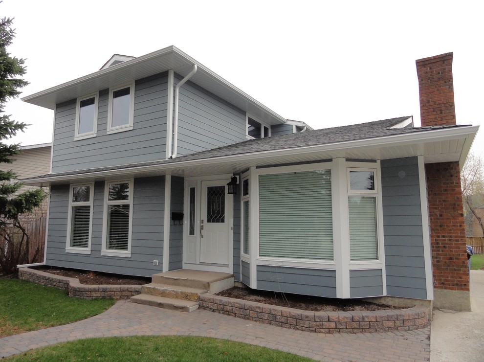 This is an example of a mid-sized traditional two-storey blue exterior in Calgary with concrete fiberboard siding.