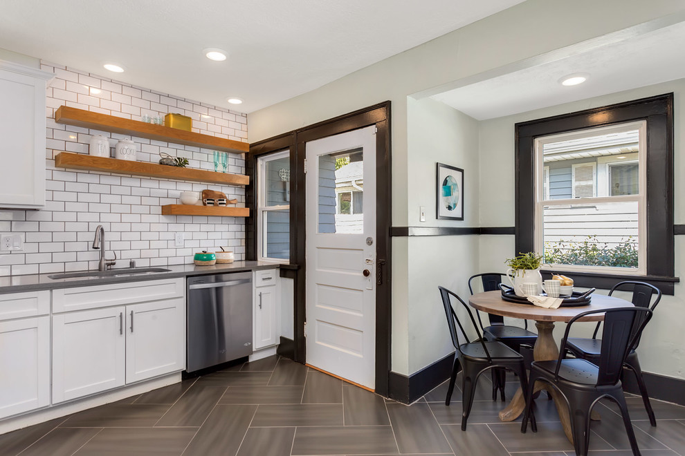 Photo of a transitional eat-in kitchen in Seattle with white splashback, white appliances, grey floor, grey benchtop, an undermount sink, shaker cabinets, subway tile splashback and no island.
