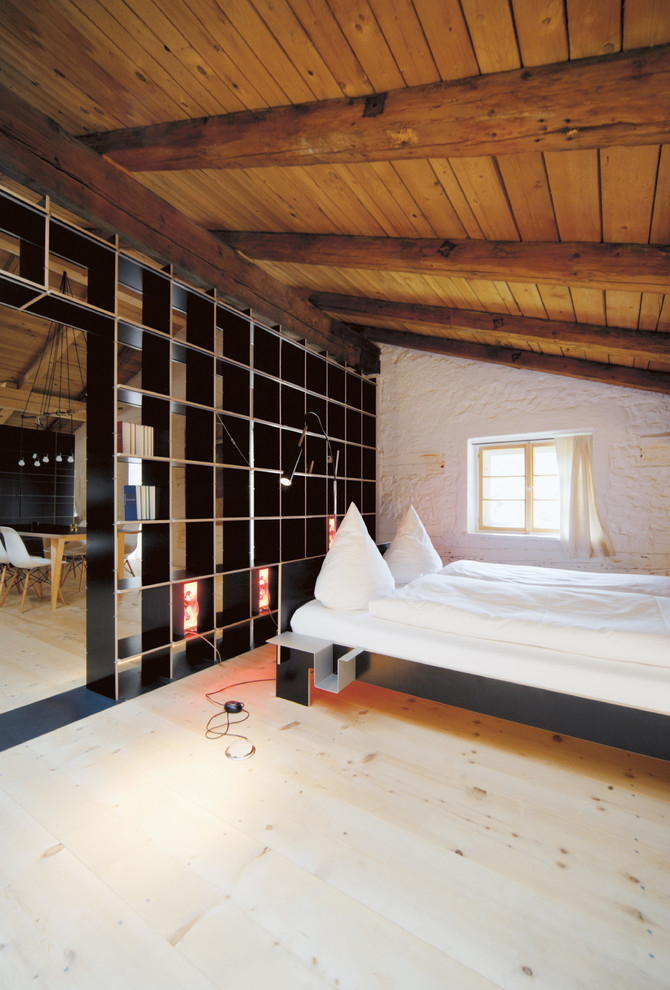 Inspiration for a mid-sized country guest bedroom in Munich with white walls, light hardwood floors and beige floor.
