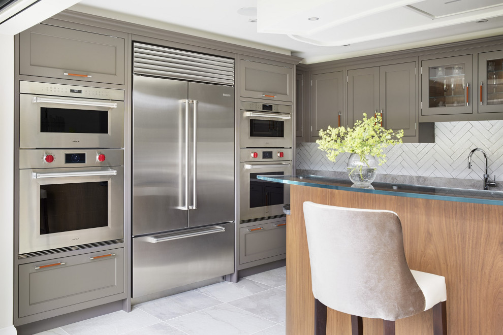 Design ideas for a contemporary kitchen/diner in Essex with an integrated sink, beaded cabinets, grey cabinets, granite worktops, white splashback, porcelain splashback, stainless steel appliances, porcelain flooring, an island, grey floors and beige worktops.