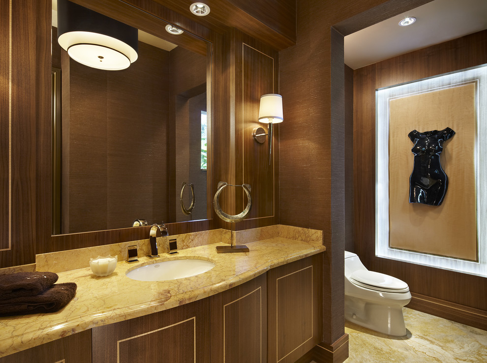 This is an example of a mid-sized contemporary powder room in Miami with furniture-like cabinets, a one-piece toilet, yellow tile, stone slab, brown walls, marble floors, granite benchtops, dark wood cabinets, an undermount sink and yellow benchtops.