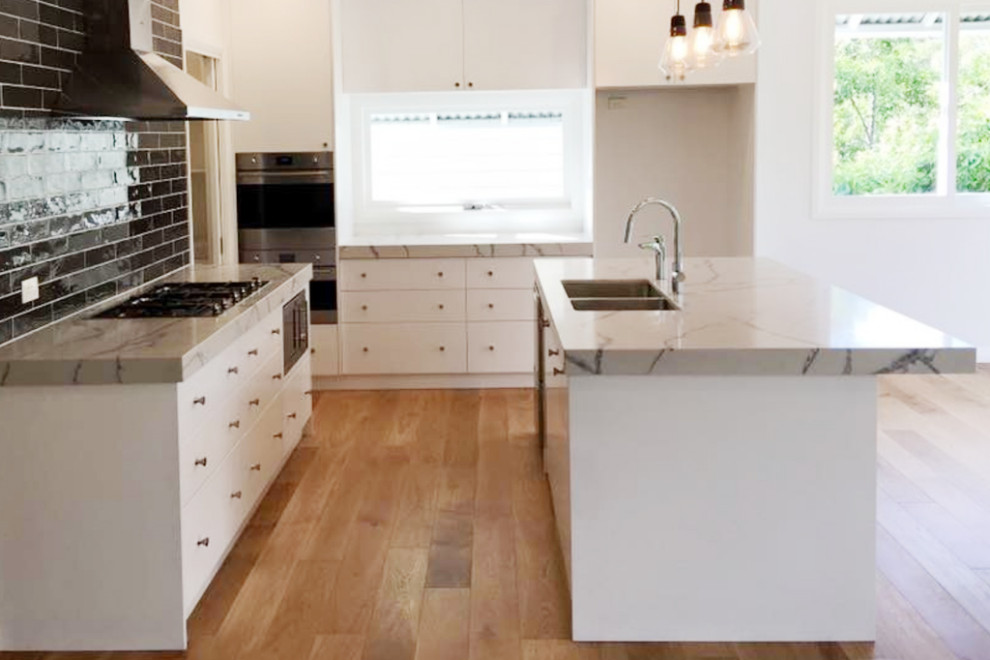 This is an example of a mid-sized contemporary galley eat-in kitchen in Sydney with louvered cabinets and with island.