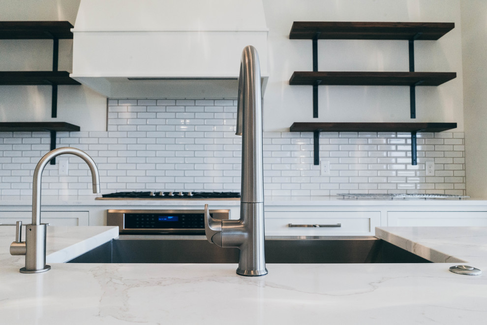 Enclosed kitchen - transitional dark wood floor enclosed kitchen idea in Omaha with a farmhouse sink, shaker cabinets, white cabinets, quartz countertops and an island
