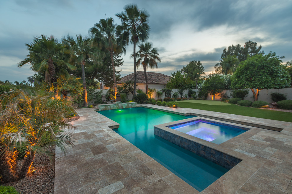 This is an example of a large mediterranean backyard custom-shaped pool in Phoenix with tile and a water feature.