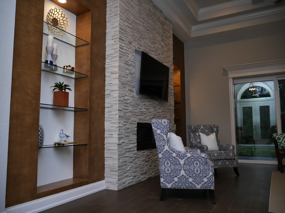 This is an example of a large transitional formal enclosed living room in Tampa with beige walls, dark hardwood floors, a ribbon fireplace, a stone fireplace surround, no tv and brown floor.