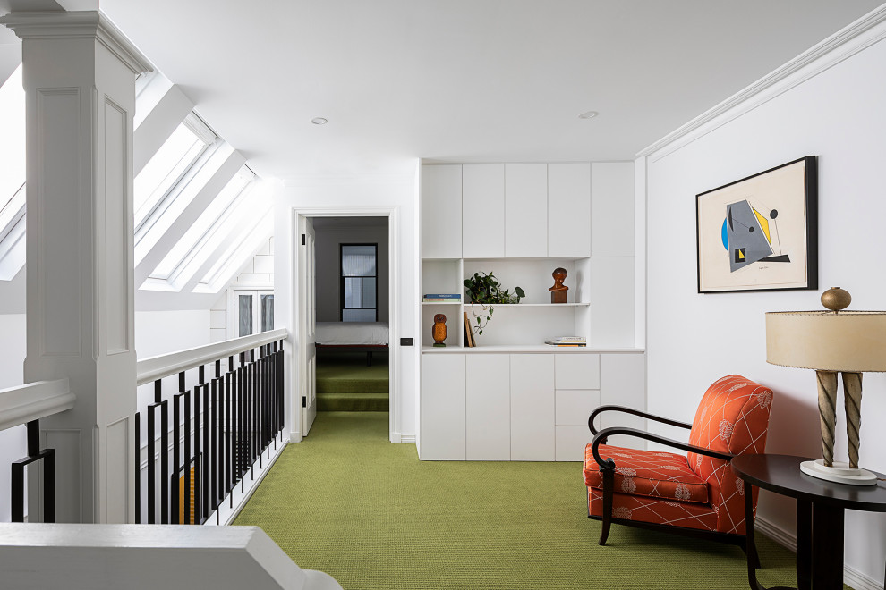На фото: маленькая двухуровневая гостиная комната в стиле фьюжн с с книжными шкафами и полками, белыми стенами, ковровым покрытием, зеленым полом, балками на потолке и панелями на стенах для на участке и в саду
