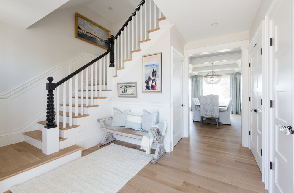 Design ideas for a beach style foyer in Boston with white walls and light hardwood floors.