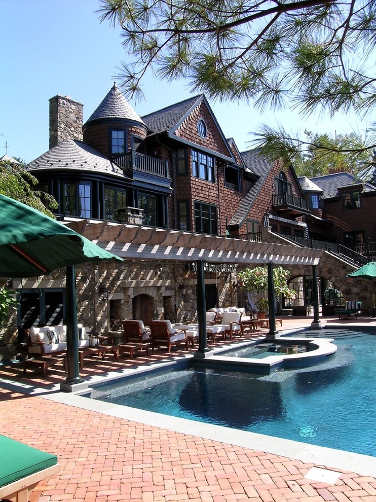 Inspiration for a traditional custom-shaped pool in New York with brick pavers.