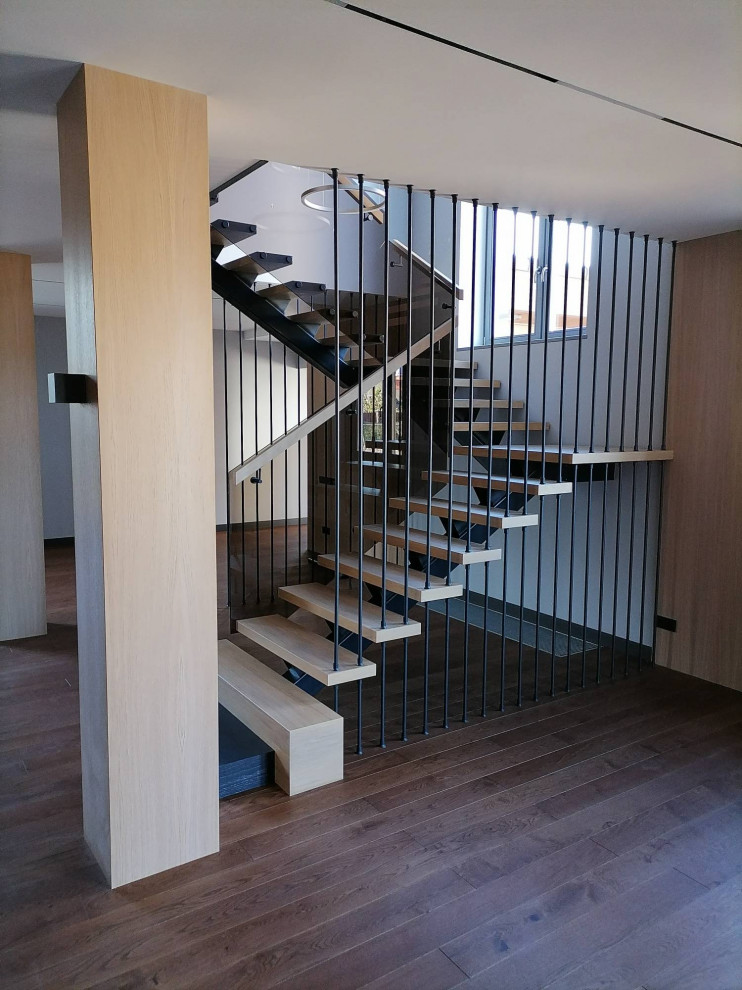 На фото: большая угловая лестница в современном стиле с деревянными ступенями и деревянными перилами