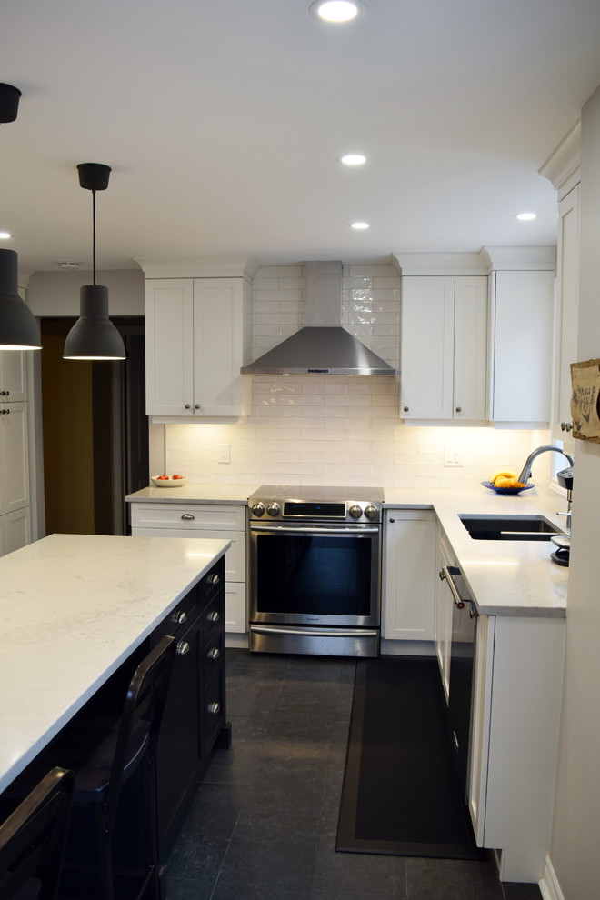 Mid-sized transitional l-shaped ceramic tile enclosed kitchen photo in Ottawa with an undermount sink, shaker cabinets, white cabinets, quartz countertops, white backsplash, subway tile backsplash, stainless steel appliances and an island