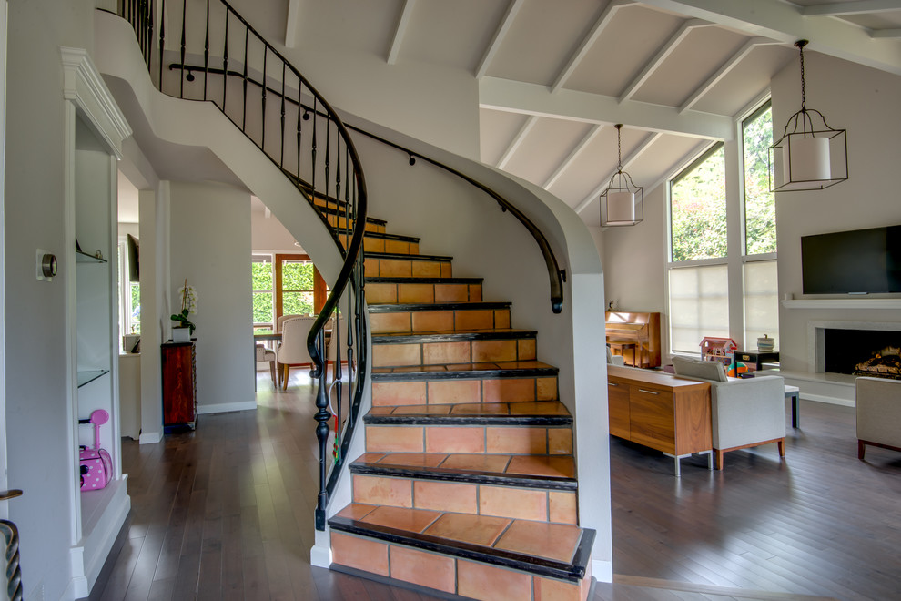 Mid-sized contemporary terracotta spiral staircase in Seattle with terracotta risers and wood railing.