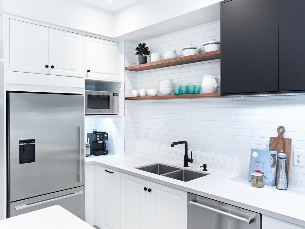 Inspiration for a mid-sized transitional galley porcelain tile and gray floor enclosed kitchen remodel in Toronto with an undermount sink, recessed-panel cabinets, white cabinets, quartz countertops, white backsplash, subway tile backsplash, stainless steel appliances and an island