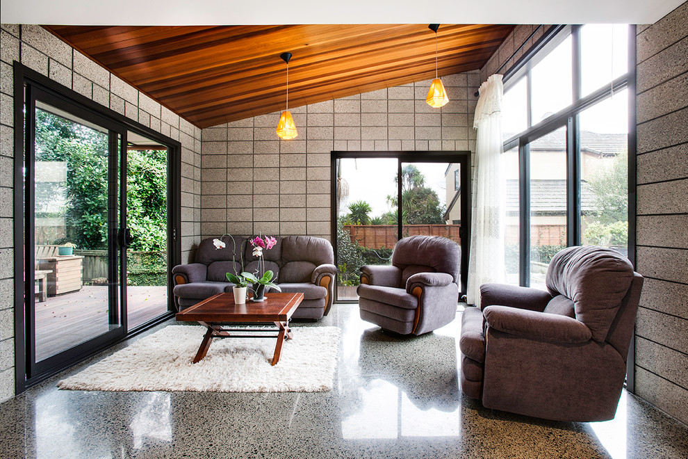 Inspiration for a mid-sized midcentury living room in Auckland with concrete floors.