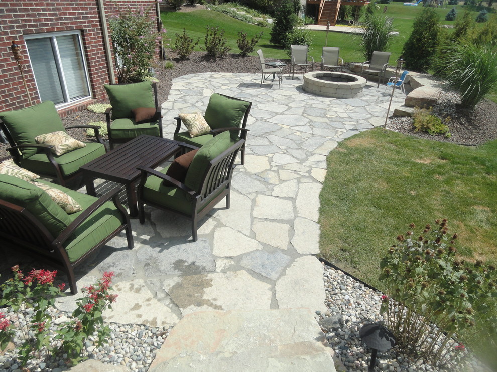 Mid-sized country side yard patio in Detroit with a container garden and natural stone pavers.