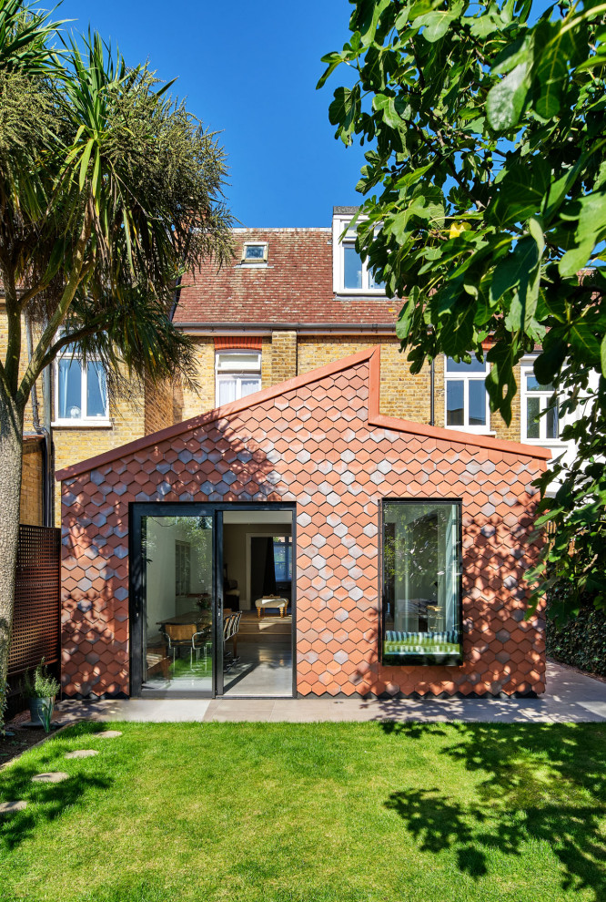 Inspiration for a red contemporary clay and front house exterior in London with a pitched roof and a red roof.