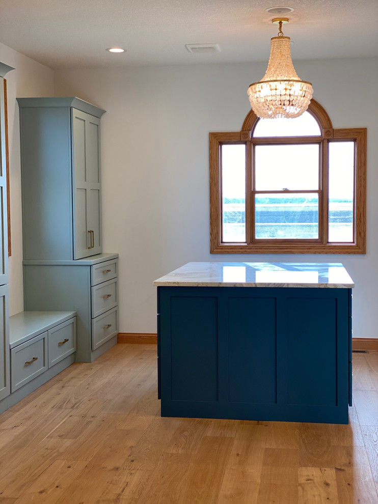 Example of a huge transitional master light wood floor, brown floor and double-sink bathroom design with shaker cabinets, green cabinets, marble countertops and a built-in vanity