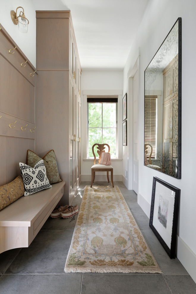 Inspiration for a country mudroom in Minneapolis with white walls and grey floor.